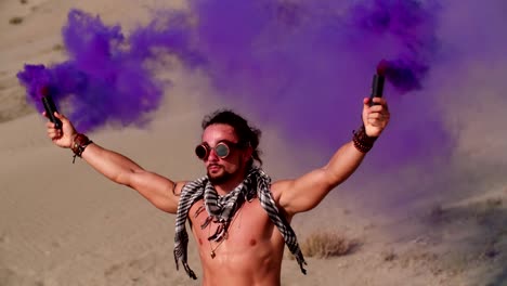 Hombre-joven-con-bombas-de-humo,-celebrando-en-el-festival-de-música-del-desierto
