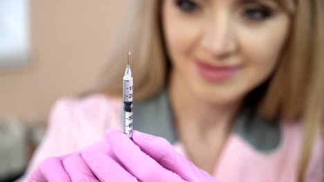 Doctor-in-a-dressing-gown-and-gloves,-preparing-an-injection-syringe.