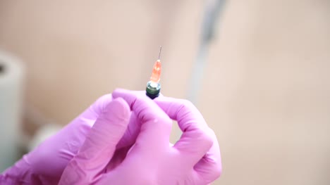 Close-up-of-cosmetician-s-hand-preparing-a-syringe-for-injection.-Blur.-Handheld-real-time-close-up-shot