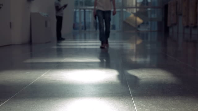 männliche-Beine-in-Jeans-zu-bewegen,-um-die-Kamera-entlang-des-Korridors-mit-künstlicher-Beleuchtung