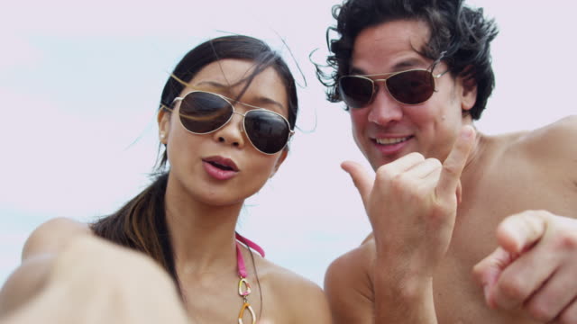 Retrato-joven-asiático-chino-pareja-película-playa-selfie