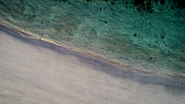 Luftbild-Wellen-brechen-sich-am-weißen-Sandstrand.