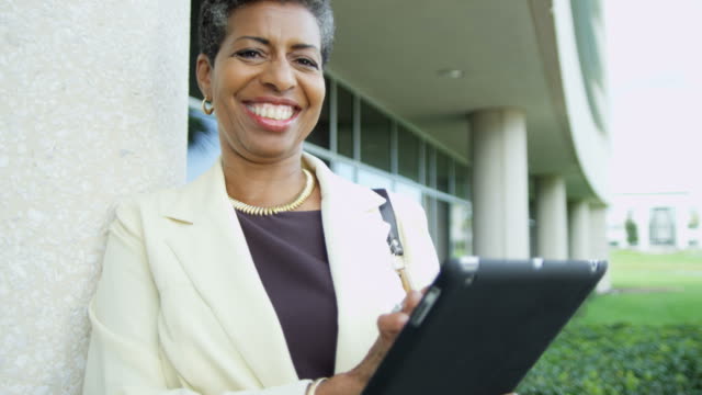 Portrait-of-African-American-female-lecturer-holding-touchscreen