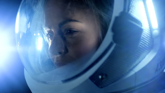 Retrato-de-hermosa-mujer-astronauta-espacio-caminando,-mirando-con-asombro,-espacio-estación-ilumina-su-rostro.-Viajes-espaciales,-exploración-y-concepto-de-colonización-del-Sistema-Solar.