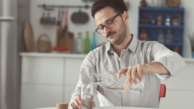 Young-man-drinking-water-in-the-kitchen