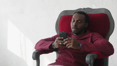 hombre-negro-utiliza-un-smartphone-para-comunicarse-en-Internet.