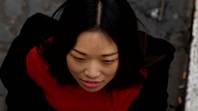 Cute-asian-woman-loking-up-and-smiles-at-camera