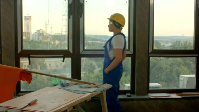 Young-worker-on-construction-site-looking-at-city
