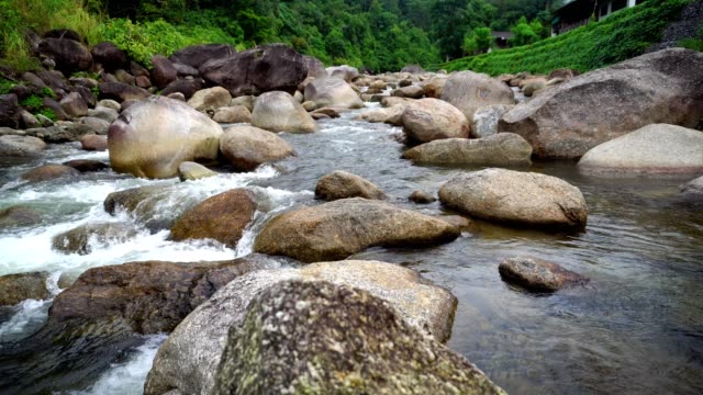 Natur-Wasser-Strömung-vom-Berg-passieren-viele-Felsen-zum-Fluss-in-dem-kleinen-Dorf.-Rauschen-des-Wasserfalls-fiel-entspannen-Sie-sich-ruhig-und-friedlich.