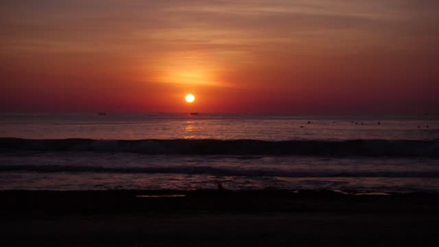 Leuchtend-bunte-Sonnenuntergang-oder-Sonnenaufgang-und-Meer-mit-Wellen-am-tropischen-Strand