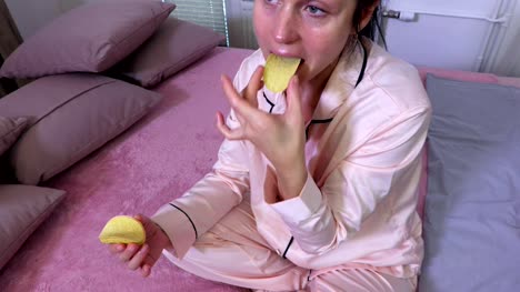 Woman-in-pajamas-eating-potato-chips
