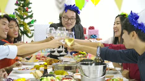 Group-of-asian-people-toasting-at-table-together-and-celebrating-Christmas-with-delicious-meal-at-new-year-party.-People-with-holidays-and-celebration-concept.
