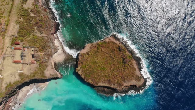 Vista-aérea-de-isla-con-rocas-y-mar-azul