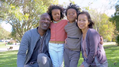 Fröhliche-Interracial-Eltern-und-Kinder-posiert-im-park