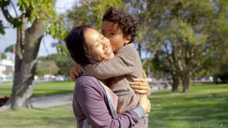 Geschweiften-afroamerikanischen-Sohn-umarmen-und-küssen-Mutter