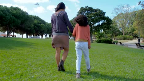 Cutly-daughter-walking-and-holding-hands-with-mother