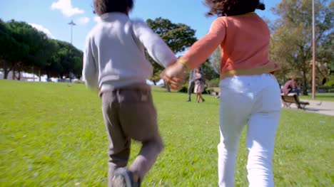 African-American-children-running-to-parents-on-green-lawn