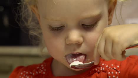 Little-cute-baby-girl-is-gently-tasting-cream-mousse