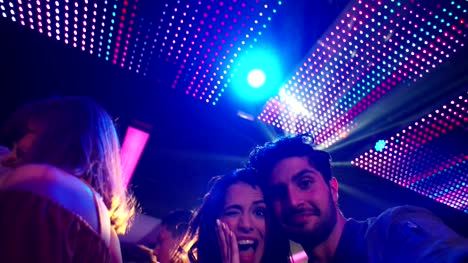 Couple-making-silly-faces-and-posing-for-selfie-in-club