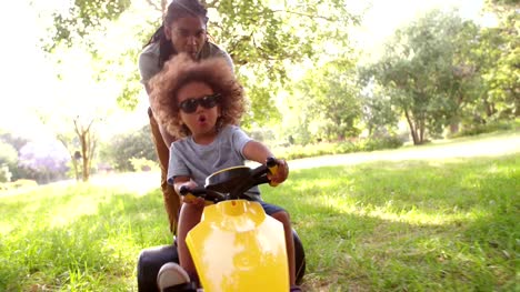 Atractivo-afroamericana-Padre-e-hijo-jugando-con-un-coche-de-pedales
