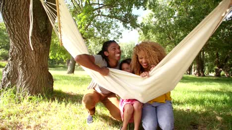 Photogenic-Multi-ethnic-family-relaxing-together-on-a-hammock