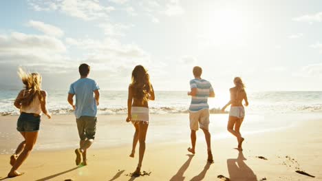 Gruppe-von-Freunden-Spaß-einem-Strandspaziergang-bei-Sonnenuntergang
