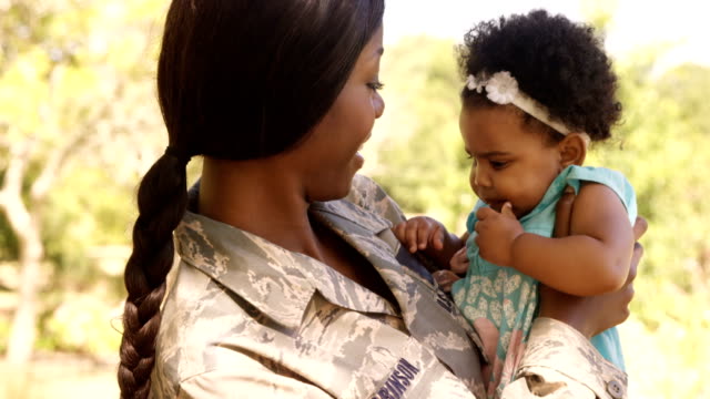 Soldier-mother-holding-her-daughter-in-a-park