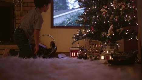 Pequeño-niño-armar-las-vías-del-tren-en-frente-del-árbol-de-Navidad
