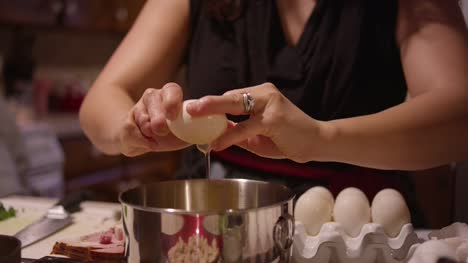 Eine-Frau-knacken-Eier-in-eine-Schüssel-geben,-in-der-Küche