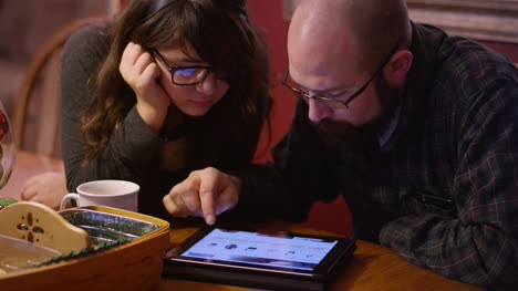 Vater-und-Tochter-auf-dem-Tisch,-Blick-auf-eine-Tablette-zusammen,-online-shopping