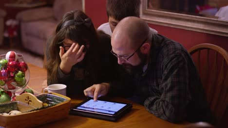 A-father-and-his-kids-looking-at-a-tablet-together,-online-shopping