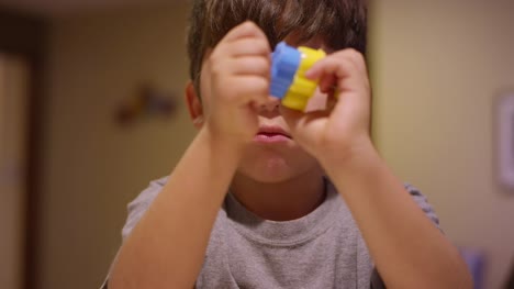 A-little-boy-using-cookie-cutters-in-the-kitchen-at-home