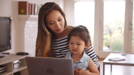 Mutter-und-Tochter-Film-auf-Laptop-zu-Hause-zusammen