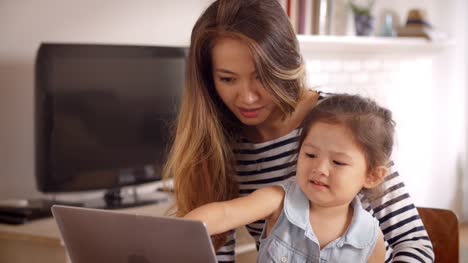 Mother-And-Daughter-Watch-Movie-On-Laptop-At-Home-Together