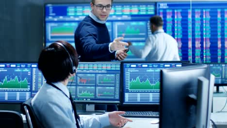 In-the-Network-Operations-Senior-Trader-Dictates-Stock-Numbers-to-Their-Operator-who-Makes-Call-with-a-Headset.-In-the-Background-Traders-Discuss-Data-Shown-on-Monitors.