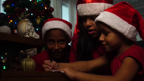 Niña,-escribir-carta-de-Navidad-a-Santa-Claus-con-su-familia