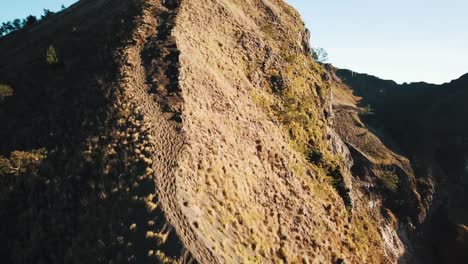 Grupo-de-amigos-caminando-por-la-colina-y-el-Pan-hasta-revelar-Monte-Batur-pico-y-cráter-volcánico-4-K
