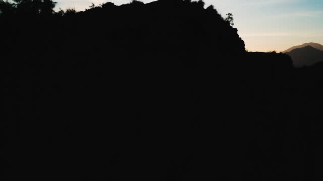 Silhouette-Gruppe-von-Freunden-stand-am-Anfang-von-einem-Vulkan-Mount-Batur-auf-Bali-mit-Blick-auf-den-Agung-In-der-Ferne-4-K