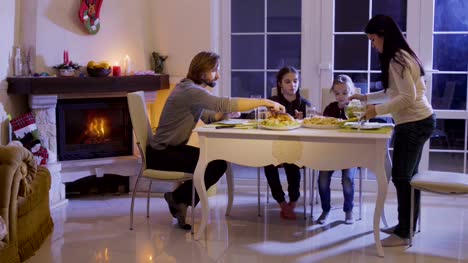 Glückliche-Familie-hat-ein-festliches-Dinner-auf-dem-Weihnachtstisch