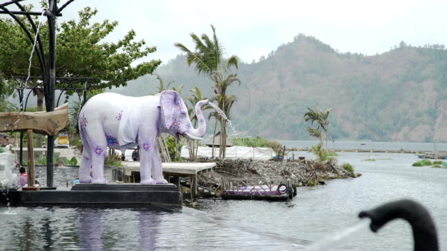 Wasser-fließt-in-Hot-Springs-Pool-vom-Stamm-der-Elefantenstatuen-Bali