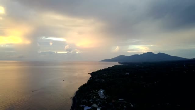 Pemuteran,-vista-aérea-de-zángano,-pedregosos-de-la-costa-y-las-montañas-en-una-puesta-de-sol.-Indonesia.-Bali