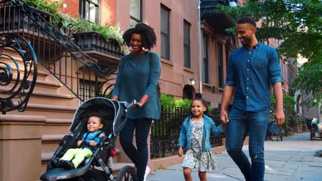 Young-black-family-with-stroller-walking-in-Brooklyn-street