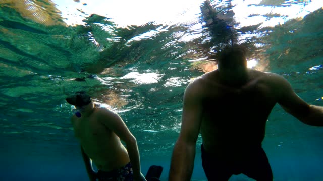 young-boy-snorkeling-with-father-on-Bali,-Indonesia