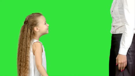 Happy-mother-giving-high-five-to-her-little-daughter-on-a-Green-Screen,-Chroma-Key