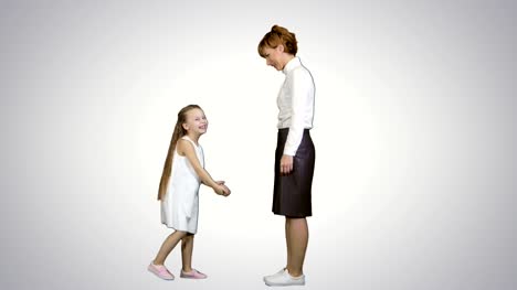 Schöne-Mutter-und-Tochter-geben-hohe-fünf-und-lächelnd-einander-auf-weißem-Hintergrund