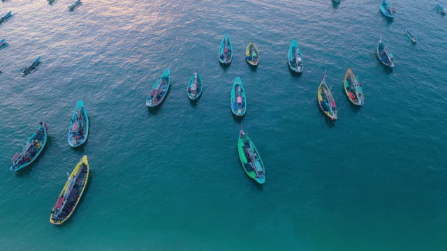 Barcos-de-pesca-tradicionales-de-Indonesia-atracado-en-orillas-después-de-pescar-una-vista-aérea,-playa-Papuma-Jember