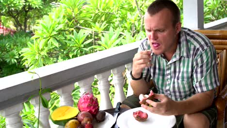 Man-sitting-on-the-balcony-cleans-the-mangosteen-fruit-and-eats