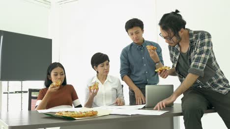 Gente-de-negocios-comer-pizza-es-tiempo-de-descanso-y-reunión-equipo-junto-para-proyecto-de-éxito.-Concepto-de-trabajo-en-equipo,-relax,-trabajo-creativo-y-compartir-la-idea.