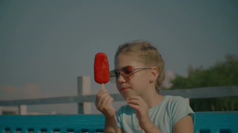 Happy-child-eating-delicious-fruit-popsicle-outdoors