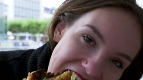Head-Shot-of-Young-Woman-Eating-Hamburger